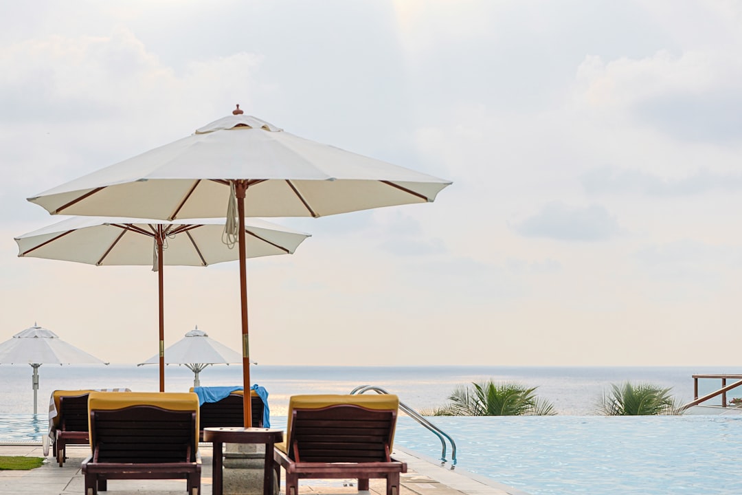a-couple-of-lawn-chairs-sitting-next-to-a-swimming-pool-avmaxzb08as